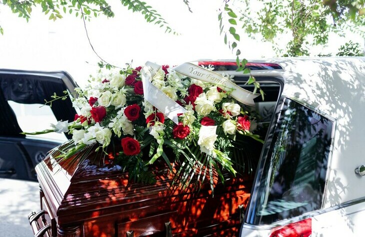 Casket with flowers in back of transport vehicle